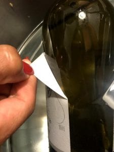 peeling label off wine bottle