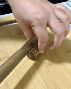 cutting wine cork in half lengthwise with knife