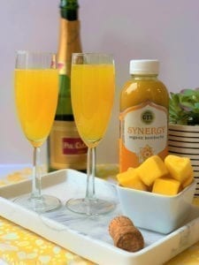 two mango mimosas, kombucha, sparkling wine, and chunks of mango