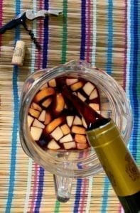 pouring red wine into pitcher for sangria
