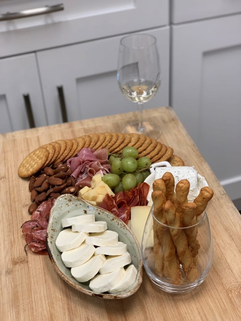 glass of white wine and charcuterie board