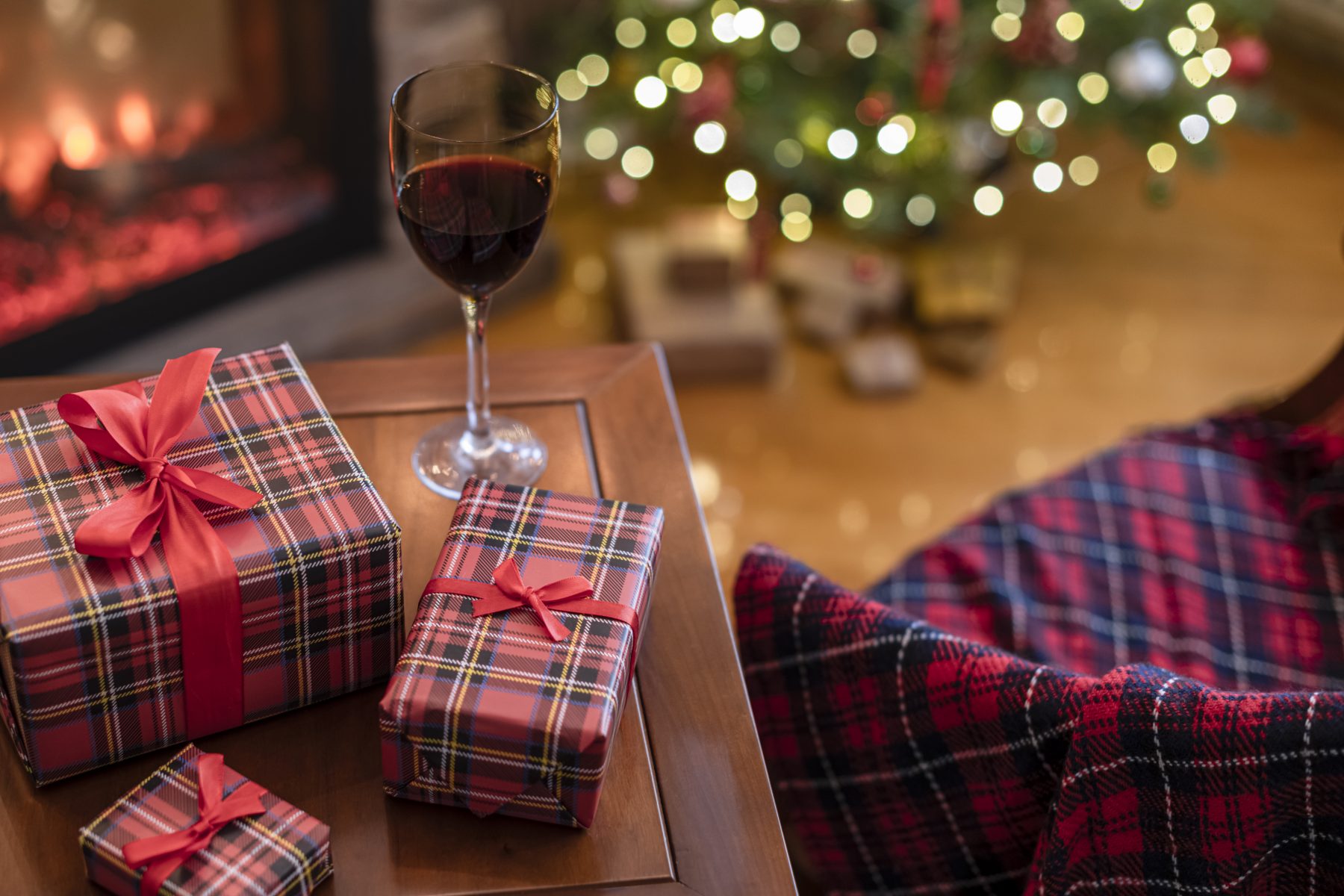wrapped gifts on table with glasses of wine