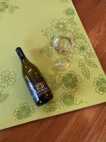 bottle of low sugar wine and glass on yoga mat
