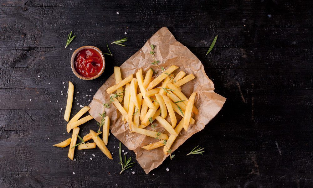 french fries on brown paper bag with side of ketchup