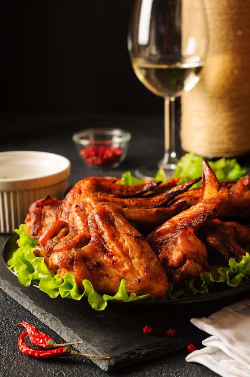 Grilled chicken wings with a glass of white wine