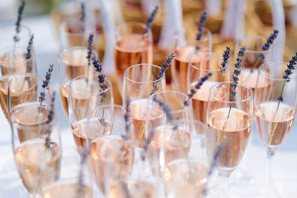 Glasses of wine with pink champagne and lavender garnish