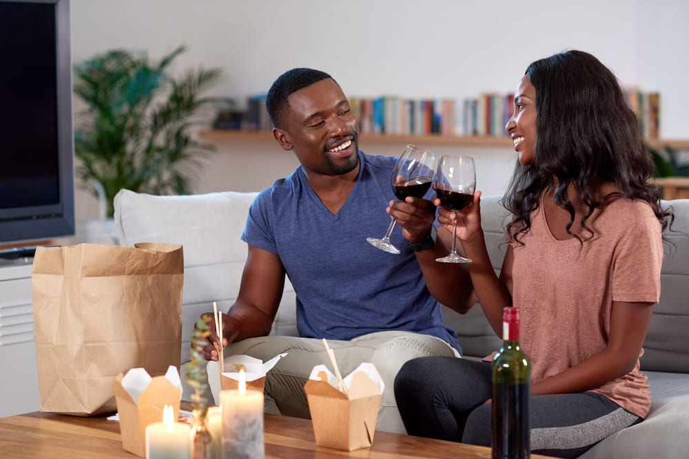 Couple enjoying wine and food delivered 