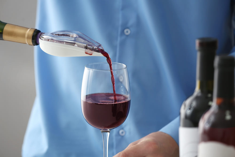 Man pouring wine with an aerator