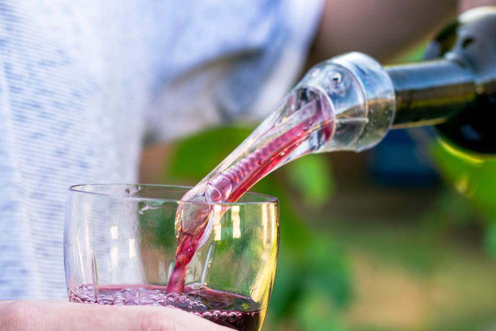 using a wine aerator to pour red wine into a glass